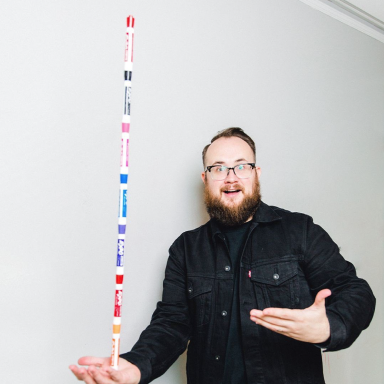 Photo of Focus Lab team member, Will, with a stack of dry erase markers stacked on one another being balanced in his hand.